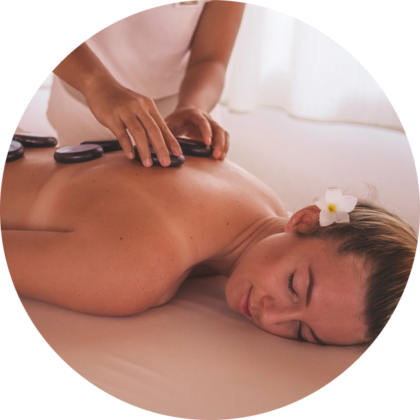 Woman receiving hot stone massage therapy.