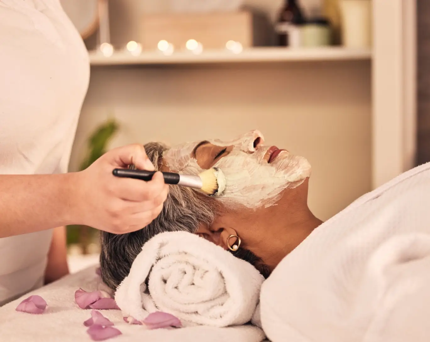 Woman receiving facial treatment at spa.